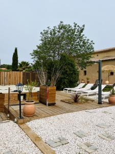 eine Terrasse mit einem Haufen Betten auf einer Holzterrasse in der Unterkunft L Atelier gîte 3 étoiles avec piscine Le Jas des Oliviers in Le Castellet