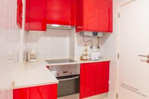 uma cozinha com armários vermelhos e um fogão em Studio in the heart of Alfama! Super Central! em Lisboa