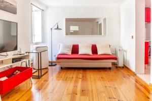 uma sala de estar com um sofá vermelho e branco em Studio in the heart of Alfama! Super Central! em Lisboa