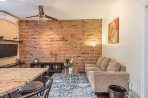 - un salon avec un canapé et un mur en briques dans l'établissement Apartment et Studio montreal, à Montréal
