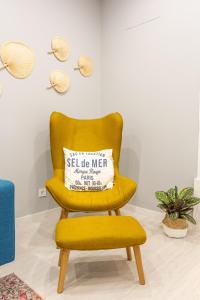 ein gelber Stuhl mit einem Kissen darauf in der Unterkunft Wonderful Brand New Apartment Belém - A few steps away from the River! in Lissabon