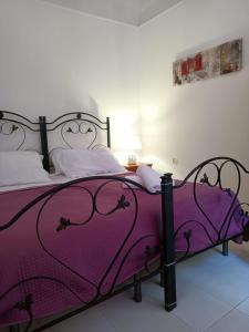 a bedroom with a purple bed with a purple blanket at TETIDE Holiday home,casa vacanze in Trapani