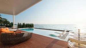 - une piscine avec une table et des chaises sur une terrasse dans l'établissement Sea Season Pool Villa Pattaya, à Bang Lamung