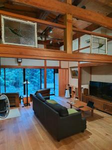 ein großes Wohnzimmer mit einem Sofa und einem TV in der Unterkunft Ryokuinsansou-bettei - Vacation STAY 48641v in Yasugi