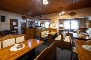 una sala da pranzo con tavoli e sedie in legno di Penzion Hubert a Mikulov v Krušných Horách