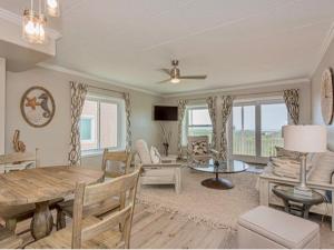 a living room with a table and a dining room at IR145 2nd Floor Condo, Ocean View, 1 Bedroom, Shared Pools, Boardwalks in Port Aransas