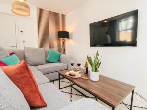 Una sala de estar con un sofá y una mesa con copas de vino. en The Salthouse Apartment 1, en Scarborough