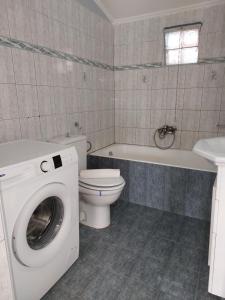 y baño con lavadora y aseo. en Lakkopetra Beach House, en Káto Achaḯa