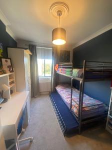 a small room with two bunk beds and a desk at Three Bedroom Family home with garden in Walthamstow in London