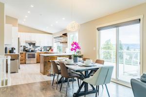 a kitchen and dining room with a table and chairs at Cozy 5BD House in North Mission Crawford in Kelowna