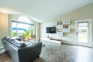 a living room with a couch and a tv at Cozy 5BD House in North Mission Crawford in Kelowna