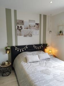 ein Schlafzimmer mit einem großen Bett und Bildern an der Wand in der Unterkunft Chambre d'hôtes salle d'eau et WC privés, véranda,extérieurs et piscine chauffée in Guérande