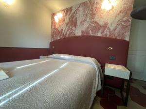 una camera con un grande letto con testiera rossa di Villa Margherita a Levanto