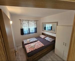 - une petite chambre avec 2 lits et un miroir dans l'établissement Apartmani Alma, à Podgora