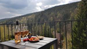 a table with two glasses of wine and a bowl of food at Apartmán Leny, Dolní Morava in Dolní Morava