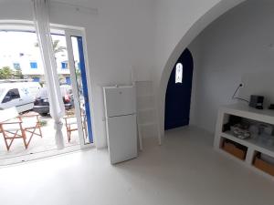 a white room with a refrigerator and a door at Νissos K in Mérikhas