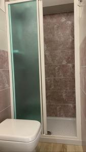 een douche met een glazen deur naast een toilet bij Il nido di Agnese in Bagni San Filippo