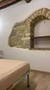 Habitación con cama y pared con arco en Il nido di Agnese, en Bagni San Filippo