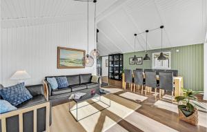 een woonkamer met een bank en een tafel bij Lovely Home In Ringkbing With Wifi in Søndervig