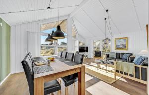 a dining room and living room with a table and chairs at Lovely Home In Ringkbing With Wifi in Søndervig