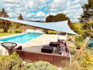 a canopy over a pool in a backyard with a swimming pool at Appartement avec jacuzzi dans la chambre et piscine aux beaux jours in Vaudancourt