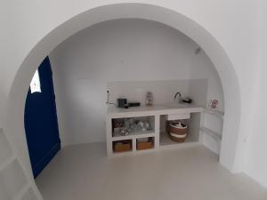 an archway in a white room with a sink at Νissos K in Mérikhas