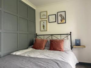 un letto con cuscini arancioni in una camera da letto di Dragon Parade Apartment a Harrogate