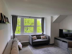 a living room with a couch and a television at Dragon Parade Apartment in Harrogate