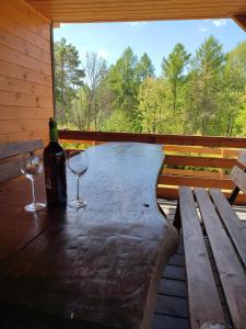 una mesa con dos copas y una botella de vino en Roztocze, Domek Na Leśnym Wzgórzu,Krasnobród,Zamość,Zwierzyniec, en Zamość