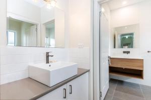 a white bathroom with a sink and a mirror at Southern Tides in Port Fairy +13 photos