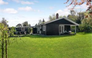 una pequeña casa con un patio delante en Beautiful Home In Fllenslev With Kitchen, en Føllenslev