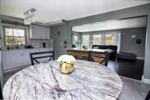 a kitchen with a table with a basket of flowers on it at The Grand Gorge Villa-With Private Yard & Parking, Minutes From Falls & Casino by Niagara Hospitaliy in Niagara Falls