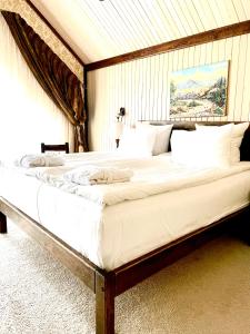 a large white bed in a room with at Nordian chalet next to Bukovel ski lift in Bukovel