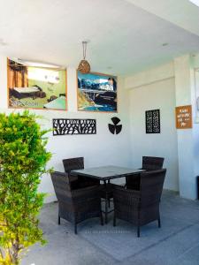 a black table and chairs in a room with a wall at Republika by Summit Resorts in Abbottabad