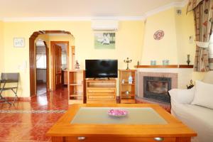 sala de estar con TV y chimenea en Villa los Olivos Spainsunrentals 1210, en Nerja