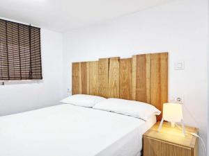 um quarto com uma cama branca e uma cabeceira em madeira em Studio Simon 1 Murcia em Múrcia