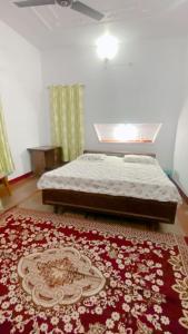 Sultānpurにあるvaishnavi homestayのベッドルーム1室(ベッド1台、赤いラグ付)