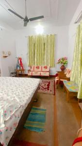 Sultānpurにあるvaishnavi homestayのリビングルーム(ベッド、椅子、カーテン付)