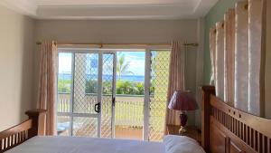 a bedroom with a bed and a view of the ocean at Sky Lodge in Nuku‘alofa