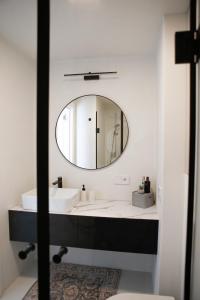 a bathroom with a sink and a mirror at Genio apartamentai Kunigiskiuose in Palanga
