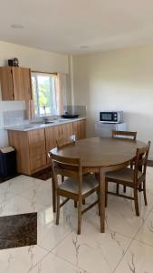 a kitchen with a wooden table and chairs and a sink at Sky Lodge in Nuku‘alofa