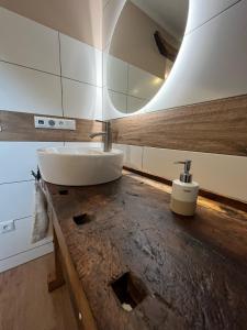 La salle de bains est pourvue d'un lavabo sur un comptoir en bois. dans l'établissement Lochhof Zwei - Eifelurlaub mit Farmcharme, à Hellenthal