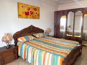 1 dormitorio con 1 cama y una pintura en la pared en Grand appart avec vue sur mer, en Oued Laou