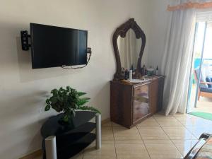 een woonkamer met een flatscreen-tv aan de muur bij Grand appart avec vue sur mer in Oued Laou