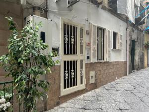 a building with an open door on a street at Vittoria's home near Maradona mural in Naples