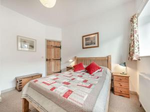 a bedroom with a bed with red pillows on it at 1 Cromwells Cottage-uk40925 in Pembroke