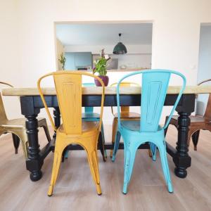 a dining room table with four chairs around it at NOUVEAUTE 2023 Maison Cocooning avec jardin, Terrasse couverte et Jacuzzi in Bellerive-sur-Allier