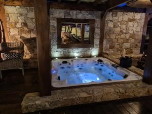 eine Whirlpool-Badewanne in einem Zimmer mit einer Steinmauer in der Unterkunft Chambre d'hôte Casa Maredda in Porticcio