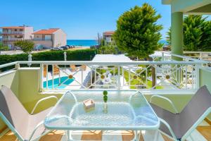 una mesa de cristal en un balcón con vistas al océano en Lafeyra Apartments, en Limenaria