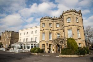 a large brick building in front of a building at Arnos Manor Hotel in Bristol